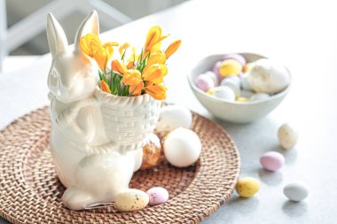 Paskalya 'da seramik tavşan, dekoratif yumurta ve ilk bahar çiçekleri.