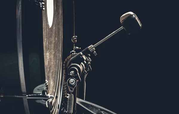 Bass drum with pedal, musical instrument on black background, copy space.