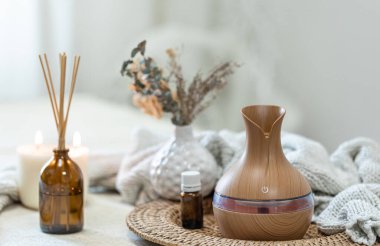 Bulanık arka planda aroma yağı yayıcı lambasıyla sıcacık spa kompozisyonu.