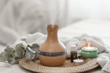 Bulanık arka planda aroma yağı yayıcı lambasıyla sıcacık spa kompozisyonu.