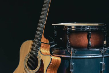 Akustik gitar ve davul siyah zemin izole edilmiş, müzik konsepti.