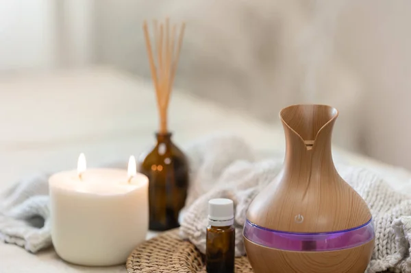 stock image Cozy spa composition with aroma oil diffuser lamp on a blurred background.