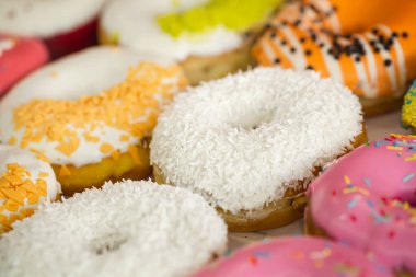 İştah açıcı çok renkli çörekler. Bir kafe vitrininde kremayla kaplanmış. Yakın plan..