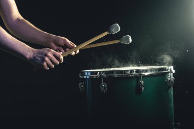 Perküsyonist, stüdyoda ışıklandırma, konser ve performans konseptinin altında sopalarla oynar..