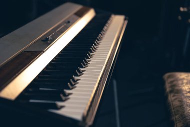 Karanlık bir arkaplanda elektronik piyano, bir müzik stüdyosunda yakın plan sentezleyici..