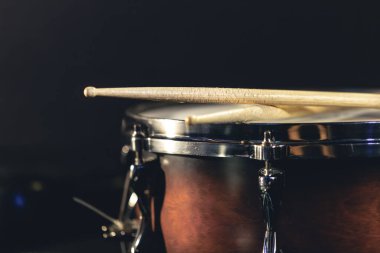 Yakın plan, davul ve bagetleri koyu arkaplanda, konser konsepti, yakın çekim enstrümanı.