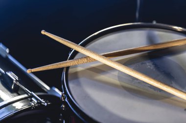 Yakın plan, davul ve bagetleri koyu arkaplanda, konser konsepti, yakın çekim enstrümanı.