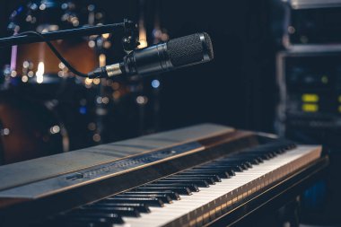Müzik stüdyosunun ya da sahnenin içindeki karanlık bir arka planda müzik tuşları mikrofonu..