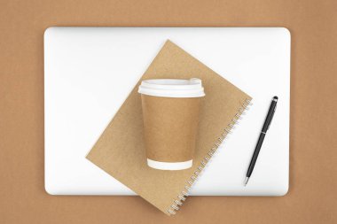 El işi kağıt kahve fincanı, kapalı spiral boş geri dönüşümlü kağıt kapaklı defter ve dizüstü bilgisayar düz konsept, eko konsepti..