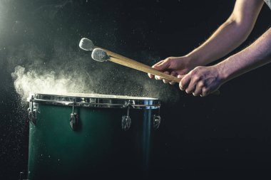 Perküsyonist, stüdyoda ışıklandırma, konser ve performans konseptinin altında sopalarla oynar..