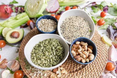 Kabak tohumları, fındık ve chia tohumları ve mutfak masasında sağlıklı sebzeler, sağlıklı beslenme konsepti..