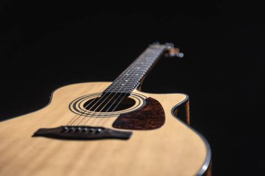 Siyah bir arkaplanda klasik bir ışık gitarını kapat, düşük tuşlu.