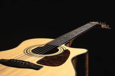 Siyah bir arkaplanda klasik bir ışık gitarını kapat, düşük tuşlu.