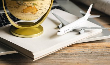 Seyahat kompozisyonu, bir uçak modeli ve ahşap bir masa üzerinde bir dünya, bilet bulma konsepti, seyahat planı, seyahat acentesi ve rezervasyon.
