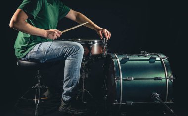 Bir erkek davulcu siyah arka planda davul çalar, profesyonel bir müzisyen davul çalar..