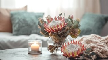 Egzotik protea çiçekli ev kompozisyonu ve bulanık oda arka planında mumlar..