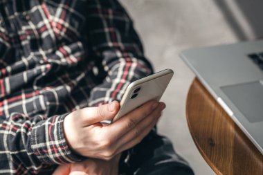 Bir adamın elinde akıllı telefon, yakın çekim teknolojisi, ofis işi, modern yaşam tarzı..