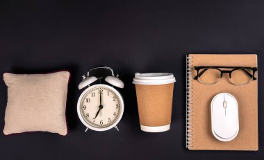 Çalar saat, kağıt bardak ve arka planda not defteri, ofis işi, üst manzara. İş yeri, sabah ofis kavramı..