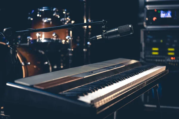 stock image Musical keys microphone on a dark background in the interior of a music studio or stage.