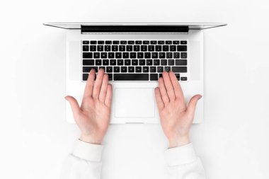 Beyaz arka planda dizüstü bilgisayar ve kadın eli, üst manzara. Uzaktan çalışma konsepti, online öğrenim, iş ve teknoloji kullanımı.
