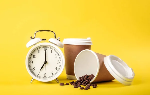 Relógio Despertador Xícara Papel Grãos Café Fundo Amarelo Isolado Conceito — Fotografia de Stock