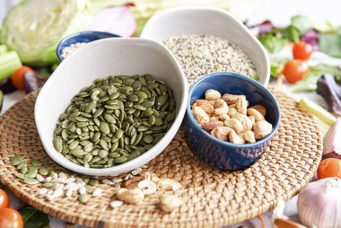 Yakın plan, kabak tohumlu kase ve mutfak masasında sağlıklı sebzeler, sağlıklı beslenme konsepti..