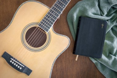 Gitar ve İncil, ahşap arka plan, üst görüş, kilisedeki müzik konsepti, ibadet..