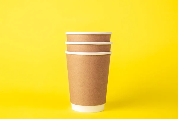 黄色の背景に分離された3つの紙使い捨てカップ エココンセプト プラスチックなし — ストック写真