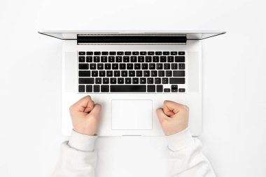 Beyaz arka planda dizüstü bilgisayar ve kadın eli, üst manzara. Uzaktan çalışma konsepti, online öğrenim, iş ve teknoloji kullanımı.