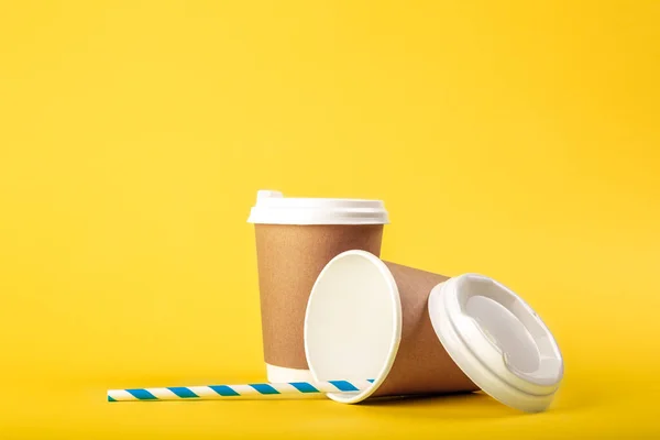 使い捨てカップと黄色の背景に分離された縞模様のわら 夏のテイクアウトドリンクのコンセプト — ストック写真