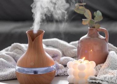 Odanın içinde bulanık bir arka planda aroma yağı yayıcı lamba ve mum içeren spa kompozisyonu.