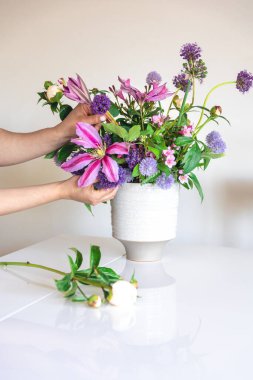 Vazo pembe yaz çiçekleri beyaz arka planda kadın ellerinde, ev dekorasyonu, bahçeden çiçekler..