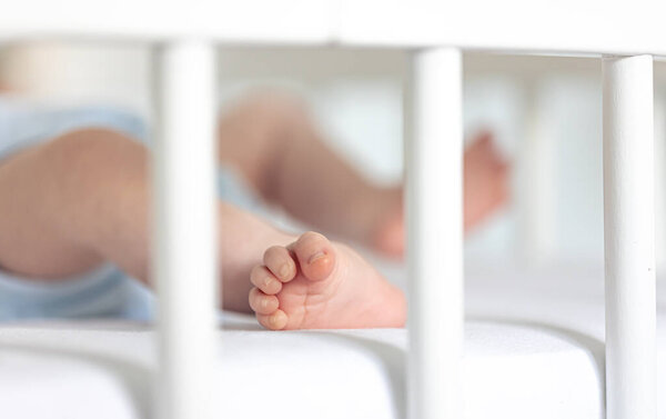 Close up view of newborn baby feet in a bed, soft focus.