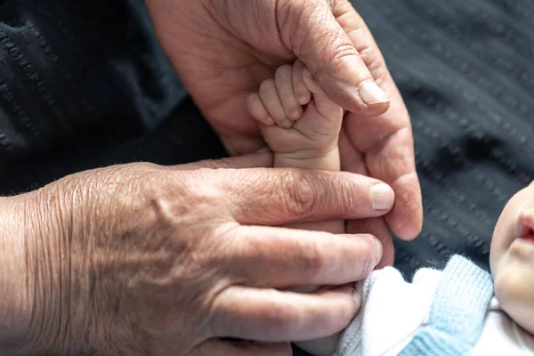 Hand Newborn Baby Hand Old Person Close Soft Focus — Stock Photo, Image