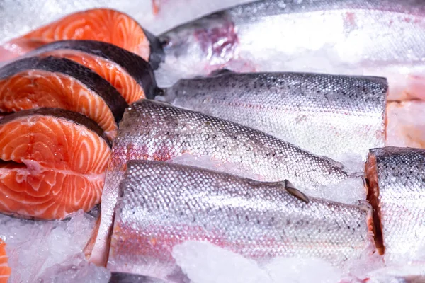 stock image Pieces of raw steak from fresh salmon lying on the ice counter at the fish market.