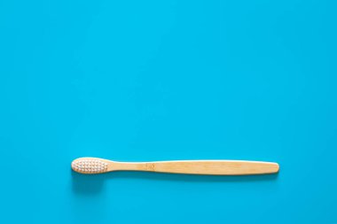 Mavi arka planda beyaz tüyleri olan doğal çevre dostu bambu fırçası, metin için kopyalama alanı, düz uzanma.