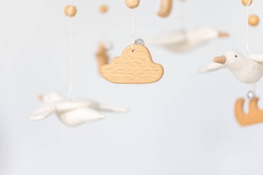 Çocuklar yeni doğan beşiğin üstünde el yapımı oyuncaklar, keçe ve ahşaptan yapılmış ilk bebek çevre dostu oyuncaklar..