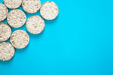Mavi arka planda pofuduk pirinç kekleri, düz yatak, üst görünüm, pirinç waffle, kopyalama alanı.