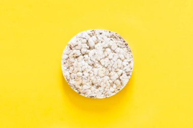 Sarı arka planda pirinç keki, izole edilmiş, düzlük, yiyecek konsepti..