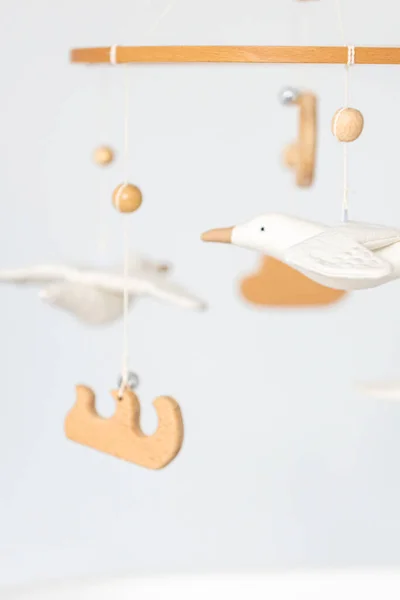 stock image Kids handmade toys above the newborn crib, first baby eco-friendly toys made from felt and wood.