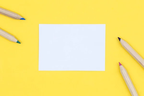 多色の木製の鉛筆と黄色の背景に紙の空白の作品 フラットレイアウト — ストック写真