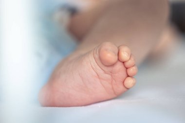 Yeni doğmuş bebek ayaklarının yatak manzarası, yumuşak odaklanma..