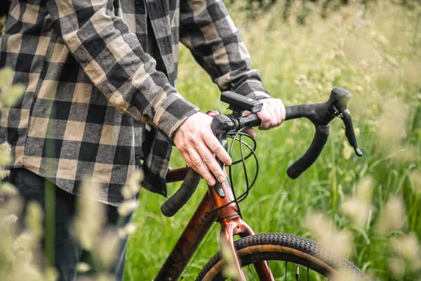 Bir Adam Bir Bisikletin Direksiyonunu Tutuyor Ormanda Yeşil Çimlerin Arasında — Stok fotoğraf