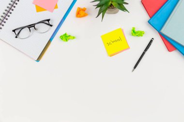 Not defterleri, gözlükler ve kağıt hatırlatıcıları beyaz arkaplan, üst görünüm, boşluk kopyala.