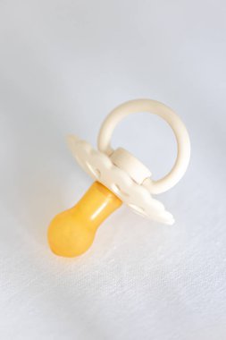 Bebek yatağında bulanık beyaz bir arka planda bebek memesi, makro çekim..