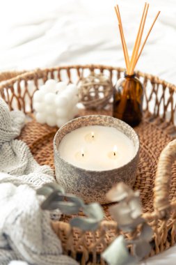Aroma yağı yayıcı lambalı spa kompozisyonu ve bulanık bir arka planda hasır tepside mum..