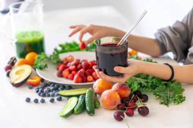 Bir bardak meyve suyu, meyveli ve sebzeli mutfak masasının arka planındaki meyveli ve meyveli meyveli meyveli meyve suyu..