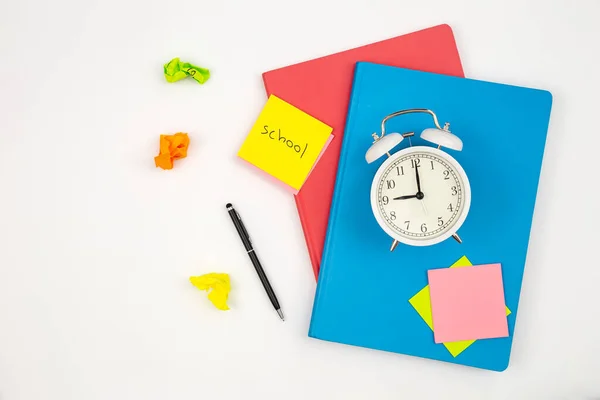 stock image Notebooks, an alarm clock and a paper reminders with on a white background isolated, top view, school concept.