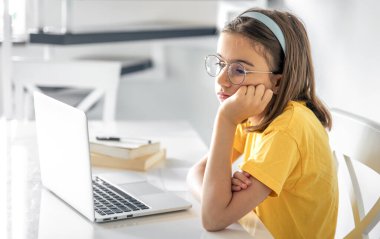 Sıkıcı öğrenci ödevlerini yaparken dizüstü bilgisayar kullanmaktan sıkılmış, üzgün genç kız sınav için hazırlanıyor..