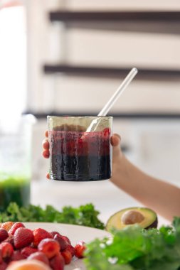 Bir bardak meyve suyu, meyveli ve sebzeli mutfak masasının arka planındaki meyveli ve meyveli meyveli meyveli meyve suyu..